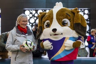 Madeleine Boll en photo avec la mascotte de l'Euro féminin 2025, baptisée Maddli en son honneur